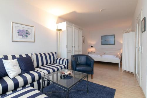 ein Wohnzimmer mit einem Sofa, einem Tisch und einem Bett in der Unterkunft Berolina Wohnung 805 Traum Ostseeblick in Dahme