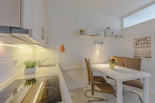 a kitchen with a table and chairs in a kitchen at Berolina Wohnung 612 in Dahme