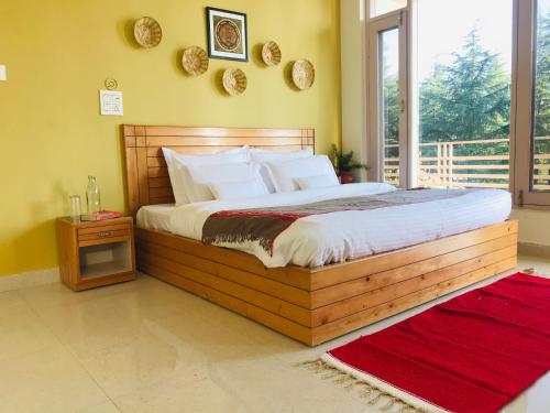 1 dormitorio con cama grande de madera y ventana en Junglaat Stays & Experiences en Dharamshala