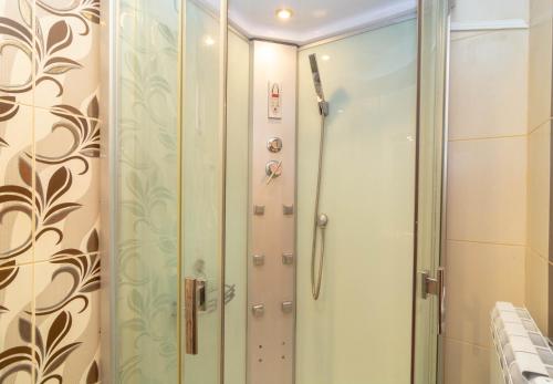a shower with a glass door in a bathroom at Fener Guest House in Pomorie