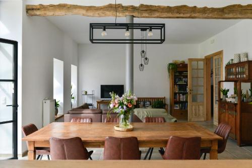 a dining room with a wooden table and chairs at B&B O Chocolat Cho in Sint-Pieters-Leeuw