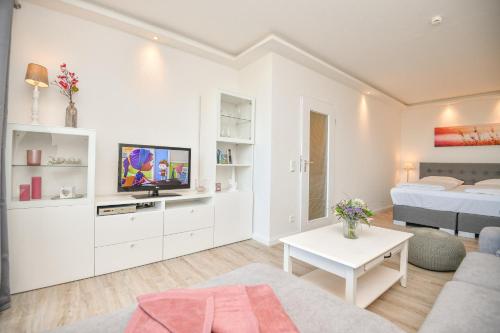 ein weißes Wohnzimmer mit einem Bett und einem Sofa in der Unterkunft Berolina Wohnung 301 in Dahme