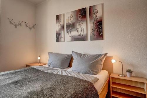 a bedroom with a bed with three pictures on the wall at Grömitz Center I Wohnung 874 in Grömitz