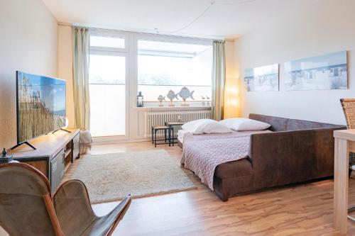 una camera con letto, divano e finestra di Driftberg 1 Haus A Wohnung 24 a Grömitz