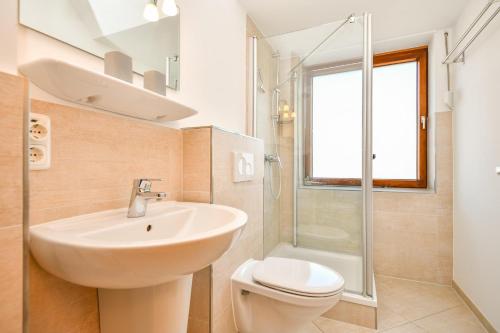 a bathroom with a sink and a toilet and a shower at Mittelweg 6 Wohnung 3 in Grömitz