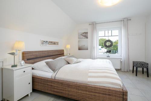 ein Schlafzimmer mit einem großen Bett und einem Fenster in der Unterkunft Seehus II in Grömitz