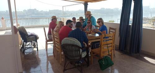 卢克索Luxor Plaza House的一群人坐在餐厅的一张桌子旁