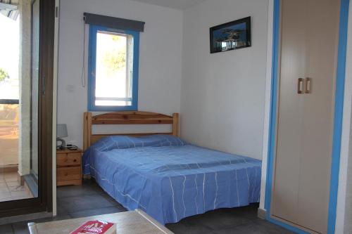 une petite chambre avec un lit et une fenêtre dans l'établissement Antigua, au Barcarès