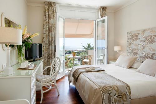 ein Schlafzimmer mit einem Bett, einem Schreibtisch und einem Fenster in der Unterkunft Hotel Il Negresco in Forte dei Marmi
