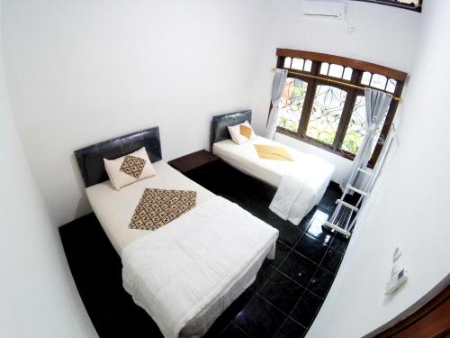 a small room with two beds and a window at Garden Yard Homestay Jogja in Ngaglik