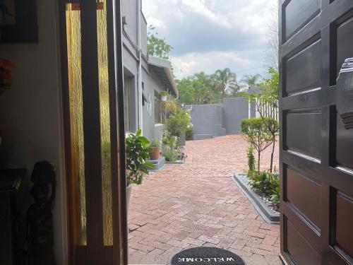 an open door to a brick courtyard with potted plants at Marion Lodge in Johannesburg