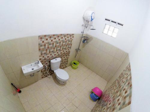 a small bathroom with a toilet and a sink at Garden Yard Homestay Jogja in Ngaglik