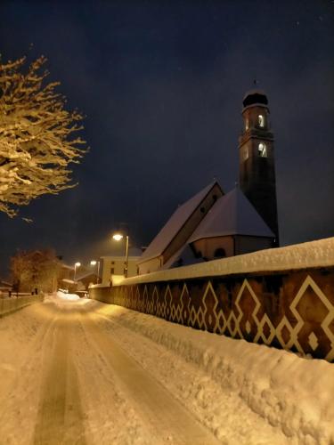 a building with a clock tower in the snow at Hotel Salgetti in Mezzano