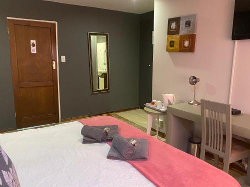 a bedroom with a bed with two towels on it at Marion Lodge in Johannesburg