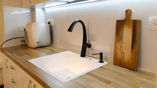 - un évier de cuisine avec un robinet sur un comptoir dans l'établissement Primrose Boutique Apartment, à Ashdod