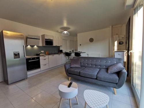 un salon avec un canapé et une cuisine dans l'établissement Villa 5 chambres - 3 salles de bain, à Étampes-sur-Marne