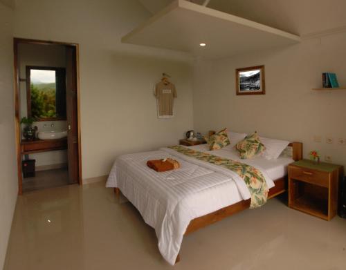 a bedroom with a large bed and a bathroom at Munduk Clove in Munduk