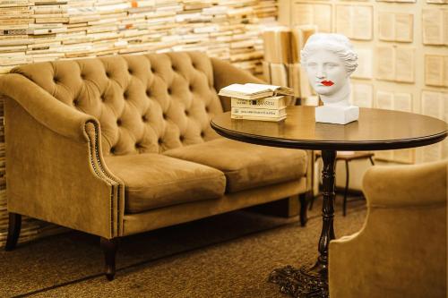 a table with a statue of a head on a table with a table sidx sidx at Old Town Hotel Bohema, Klaipėda in Klaipėda