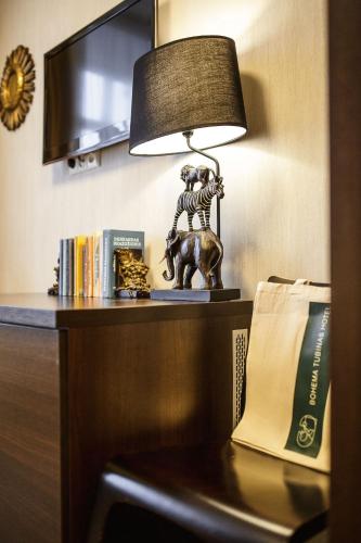 a table with a lamp on a desk with books at Old Town Hotel Bohema, Klaipėda in Klaipėda