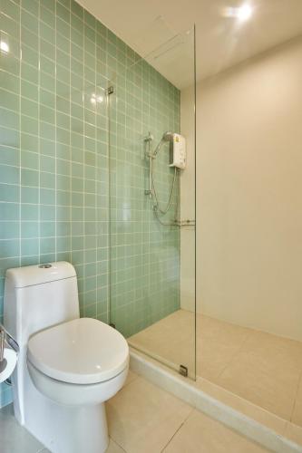 a bathroom with a toilet and a glass shower at Talay Hotel and Villa Cha-am in Cha Am