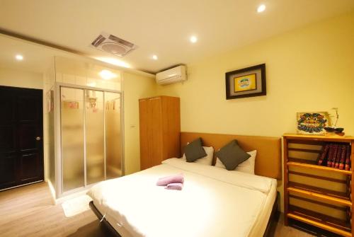 a bedroom with two beds and a book shelf at Dabing home in Tainan in Tainan
