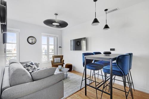 a living room with a couch and a table and chairs at Maison Labruyère Bordeaux - Jardin Public in Bordeaux