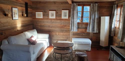 a living room with a white couch and a table at Chalet le Grenier - Romantique et exclusif in Champéry