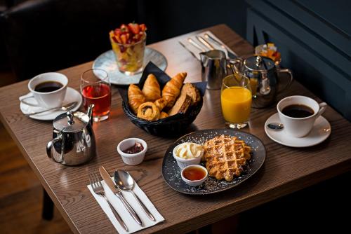 a wooden table with breakfast foods and drinks on it at George Limerick Hotel in Limerick