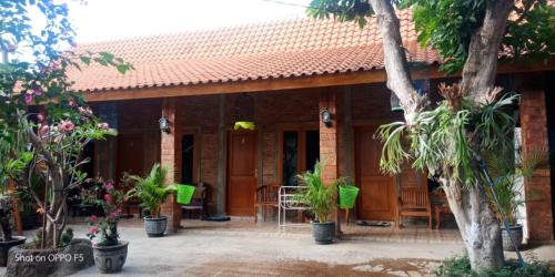 a house with trees and plants in front of it at Nita's Homestay Banyuwangi in Banyuwangi
