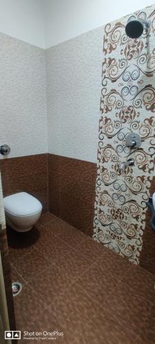 a bathroom with a toilet and a shower curtain at Hotel City Palace in Varanasi