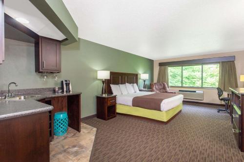 una camera d'albergo con letto e lavandino di AmericInn by Wyndham West Salem a West Salem