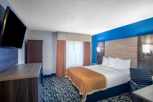 a hotel room with a bed and a flat screen tv at Baymont by Wyndham Branson - On the Strip in Branson