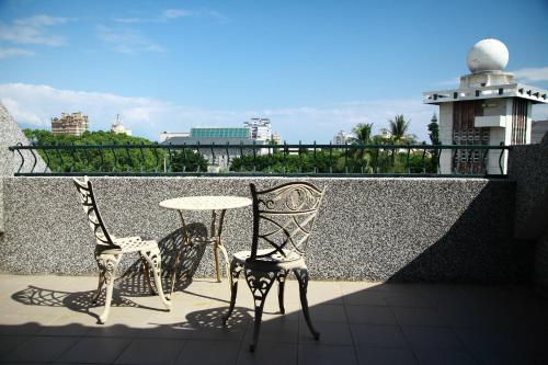 two chairs and a table on a balcony at Yangpin House Homestay in Hualien City