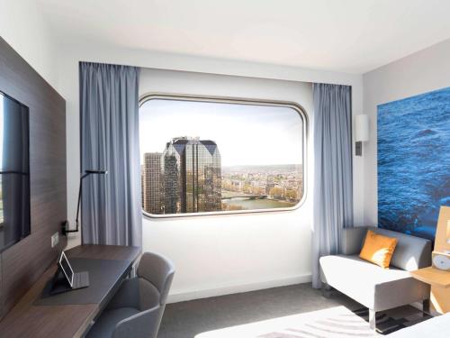 a hotel room with a window with a view of the city at Novotel Paris Centre Tour Eiffel in Paris