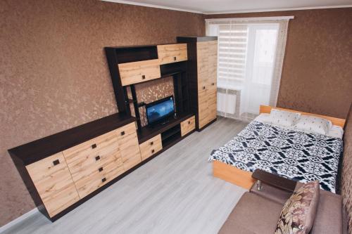 Un dormitorio con una cama y un televisor. en The Cool Home Лавина пр М Лушпы 5 корпус 27, en Sumy