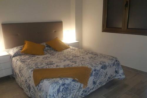 Un dormitorio con una cama con dos almohadas amarillas. en Victoria 51.(Plz España). Playa de Las Canteras, en Las Palmas de Gran Canaria