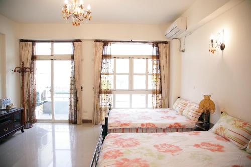 um quarto com 2 camas e um lustre em Yangpin House Homestay em Hualien