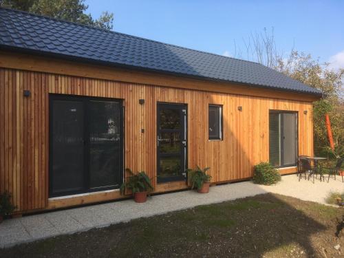 ein Holzgebäude mit großen Fenstern und einer Terrasse in der Unterkunft Zahradní dům in Bělkovice