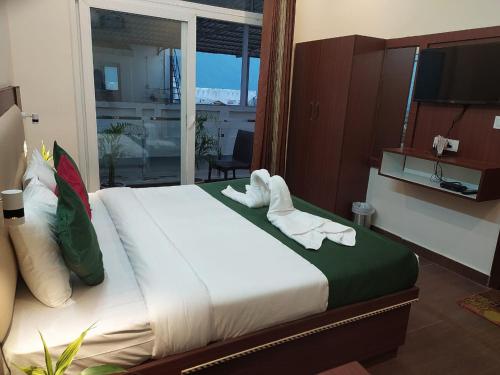 a hotel room with a bed with towels on it at Hotel The Shivaay - Delight Inn Rishikesh in Rishīkesh