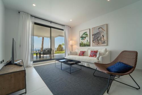 a living room with a couch and a tv at Estepona Holiday Hills in Estepona