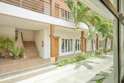 an external view of a building with plants at Talay Hotel and Villa Cha-am in Cha Am