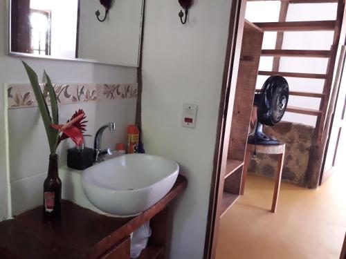 a bathroom with a white bowl sink on a counter at Chalé Rio dos Meros in Paraty