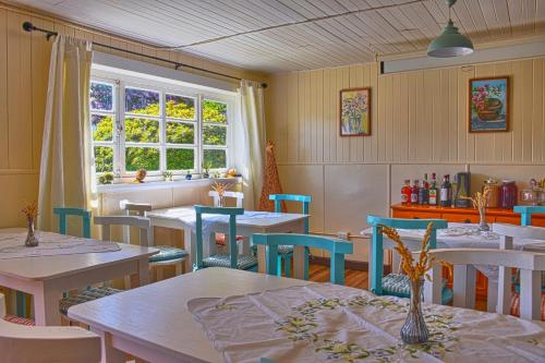 ein Esszimmer mit Tischen, Stühlen und einem Fenster in der Unterkunft Hostal Triwe in Puerto Octay