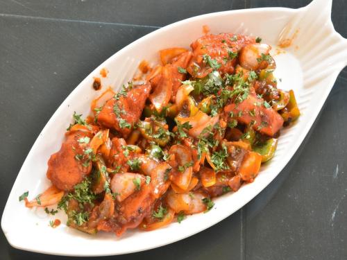 a white plate of food with shrimp and vegetables at Hotel The Shivaay - Delight Inn Rishikesh in Rishīkesh