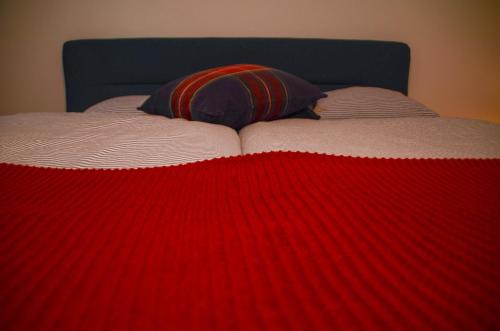 a red and white blanket on top of a bed at appartement DE WATERLIJN in Knokke-Heist
