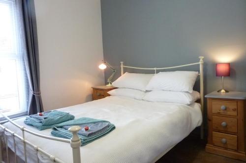 Un dormitorio con una cama blanca con toallas. en A wonderful place in the hub of the city, yet on the edge of the countryside en Salisbury