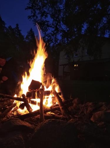 a fire burns in a fire pit at night at Leśny Dworek in Kryłatka