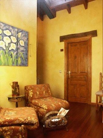 a living room with a couch and a chair at Hotel Rural Sucuevas in Mestas de Con