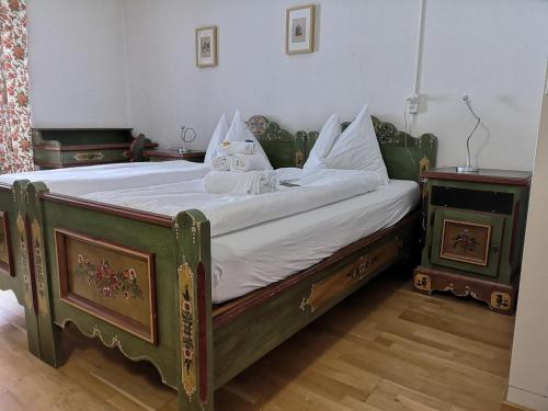 a green bed with white sheets and pillows on it at Historisches Hotel Piz Ela Bergün in Bergün