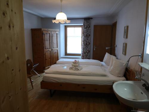 a bedroom with a bed with a teddy bear on it at Historisches Hotel Piz Ela Bergün in Bergün